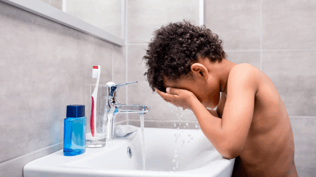 child washing their face as part of an eczema-friendly skincare routine